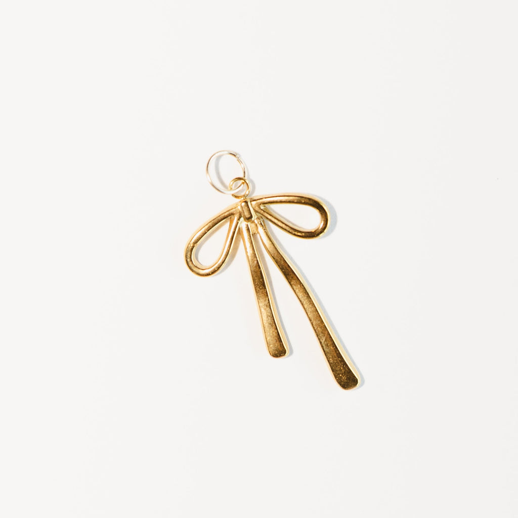 Gold bow-shaped pendant on a white background